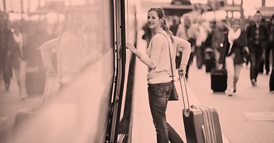 Pretty young woman boarding a train (color toned image)